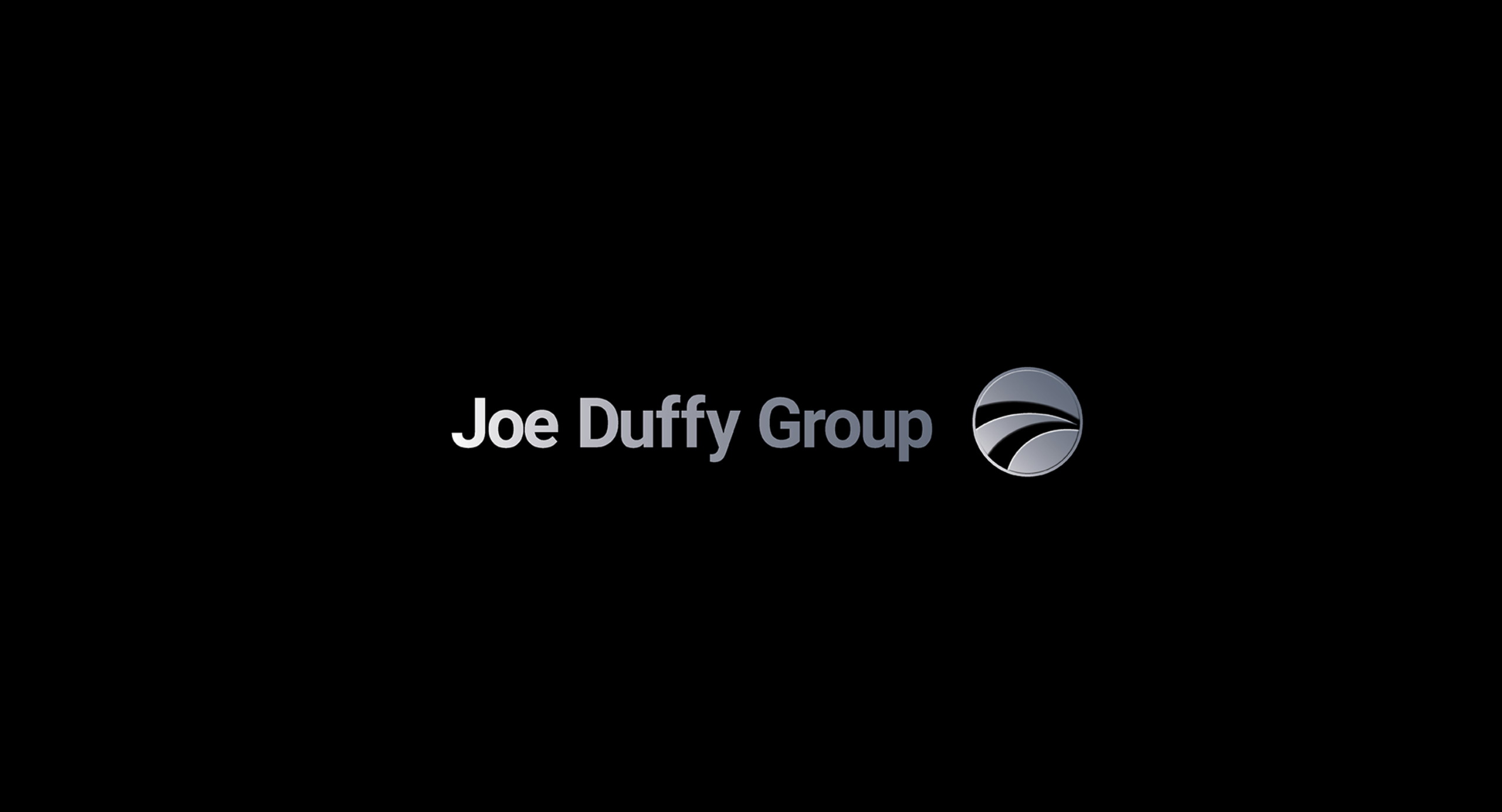 Joe Duffy Group logo — silver wordmark and circular emblem on black